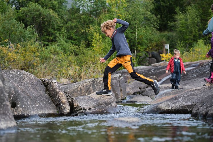 Boy jumping over a stream Photo Matias Fosso