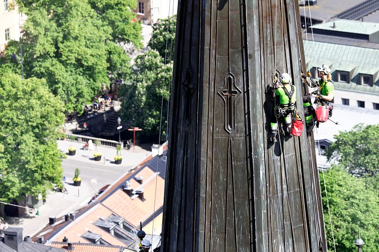 Klättrare utför fogningsarbeten på tornen på Uppsala Domkyrka