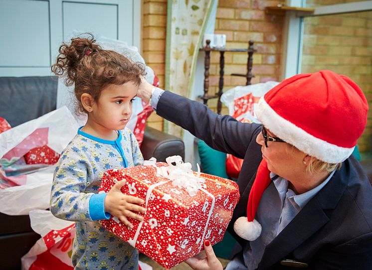 Flicka på asylboende får julklapp av en av Mimers anställda