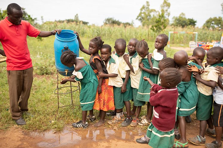 Barn på förskola i Uganda tvättar händerna. 
