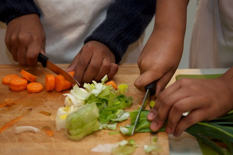 Elever skjærer grønnsaker på Geitmyra matkultursenter