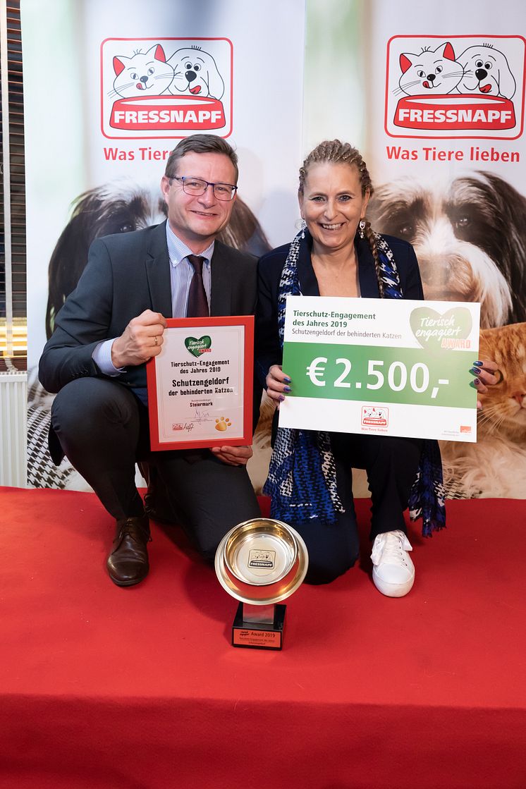 Hermann Aigner übergibt den goldenen Fressnapf an Renate Riedel vom Schutzengeldorf der behinderten Katzen