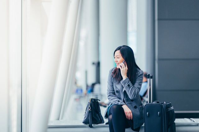 Web-Businesswoman talking on smartphone in airport