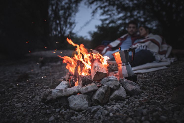 Rieden am Forggensee_Forggensee_Ein_Paar_sitzt_abends_am_Ufer_beim_Lagerfeuer