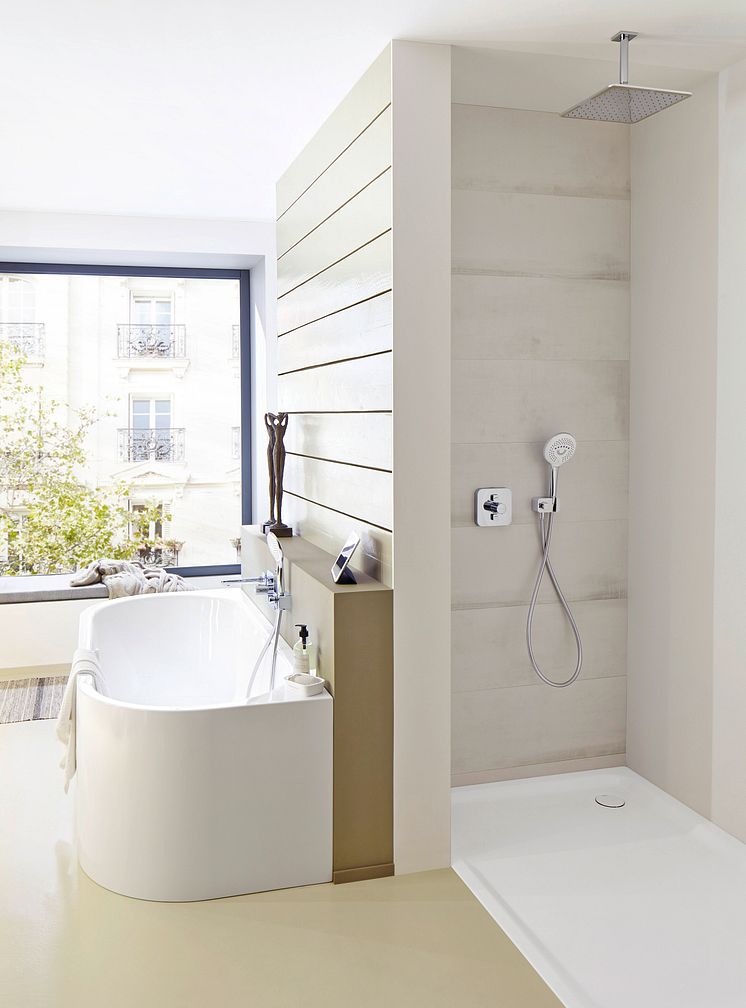 Ein Badezimmer mit einer abgerundeten Badewanne und einer bodenebene Dusche von Kaldewei.