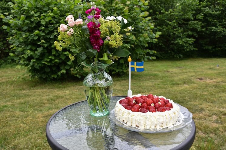 mp32850452-jordgubbstarta-svensk-flagga-och-sommarblommor-i-en-gron.jpg