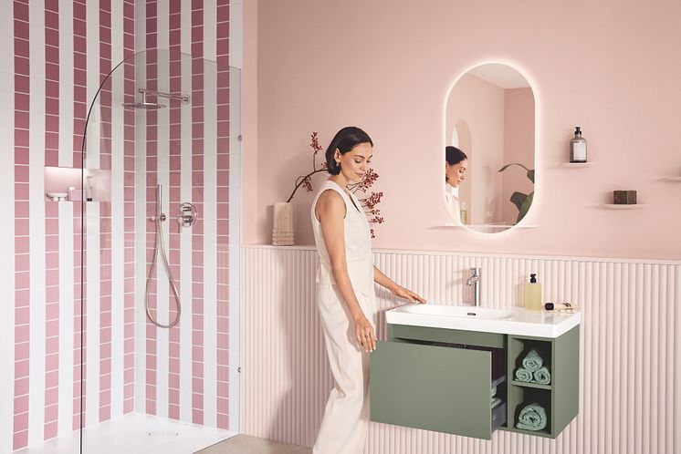 Eine Frau ist in ihrem Lifestyle-Badezimmer von Villeroy & Boch zu sehen und öffnet die Schublade vom Unterschrank.
