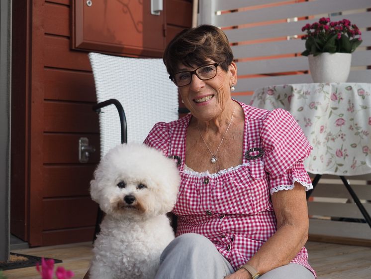 Inger framför sitt kloka hus