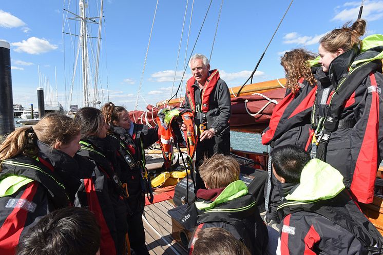 Hi-res image - Ocean Signal - Head of Sailing at Dauntsey’s Toby Marris briefs the Jolie Brise crew about the Ocean Signal rescueME MOB1