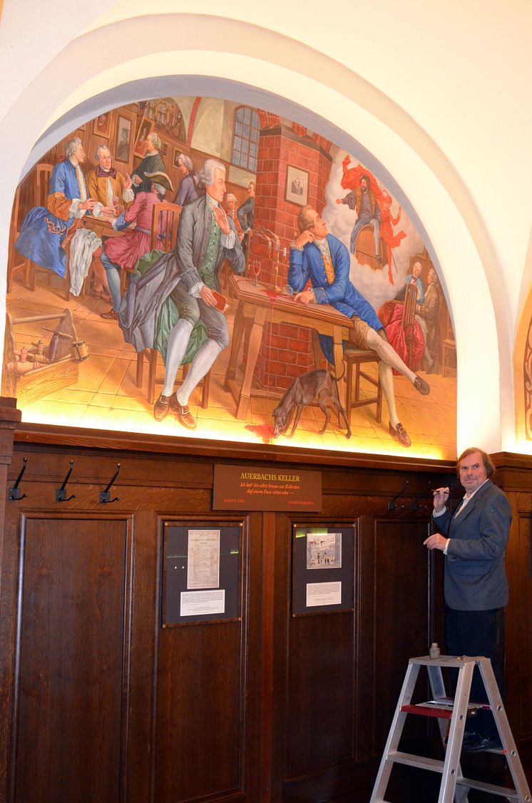 Künstler Volker Pohlenz signiert das Wandgemälde „Goethes Faust-Inspirationen“ in Auerbachs Keller