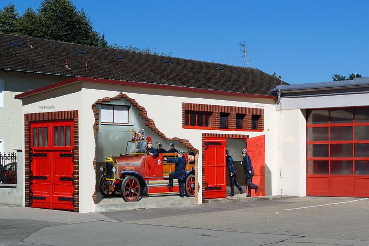 Kunst am Trafo: Historisches Löschfahrzeug am Feuerwehrhaus in Neuötting