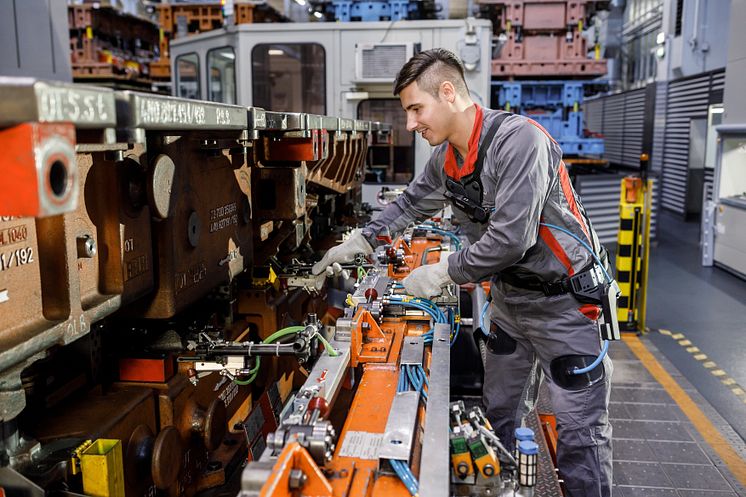 When preparing the transfer press, an employee uses the exoskeleton in the press shop at the Neckarsulm plant