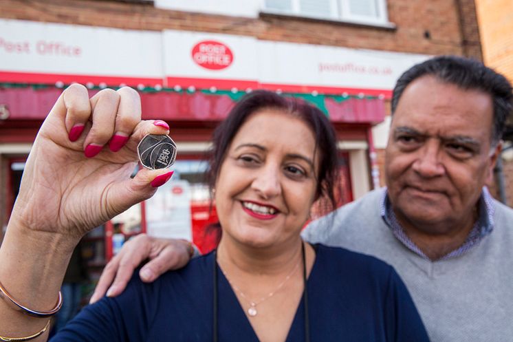 Postmaster Umesh Sanghani and his wife Rashmita outside Dedworth Green Post Office coin at forefront low res