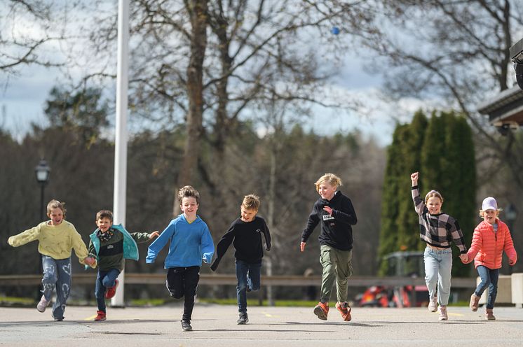 Barn på skolgård lekar utomhus