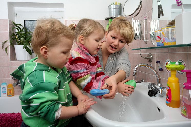 Händewaschen nicht vergessen, Mädchen mit Mutter und Bruder