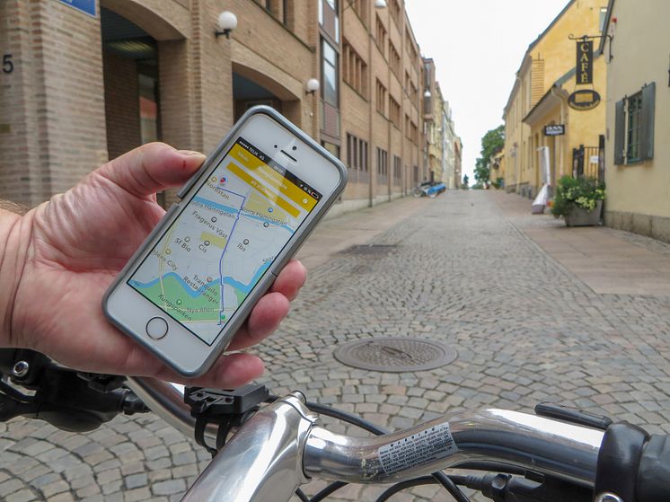 Appen Cykelstaden i mobil i hand på cykelstyre
