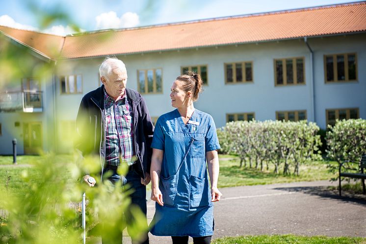 Anställd promenerar och pratar med omsorgstagare_KungsbackaKommun