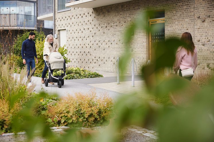 man äldre barnvagn hus