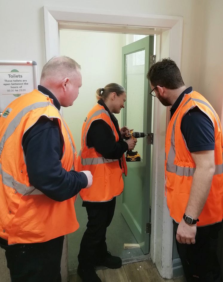 Natalie Parker repairing a toilet door at Worthing station in her first week