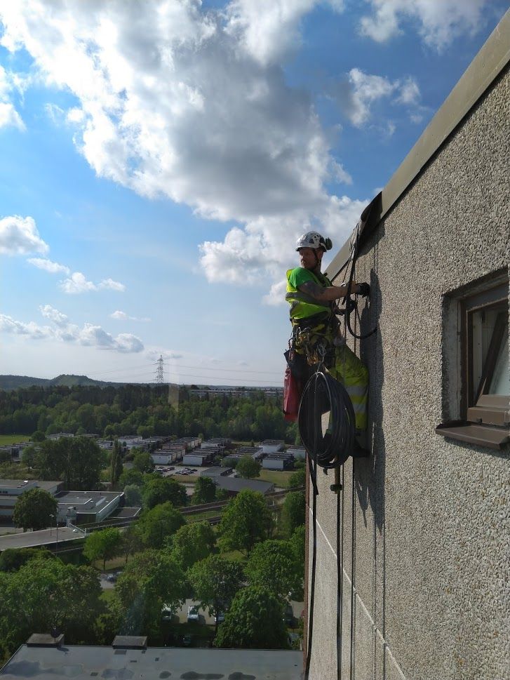 Reparbetare från Klätterservice utför fasadreparation.