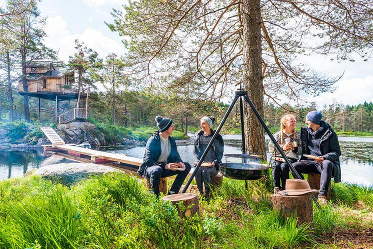 Friends eating around a bonfire Fiddan Treetop Cabin, Lyngdal -Photo - Paul Hughson – TravelStock.jpg