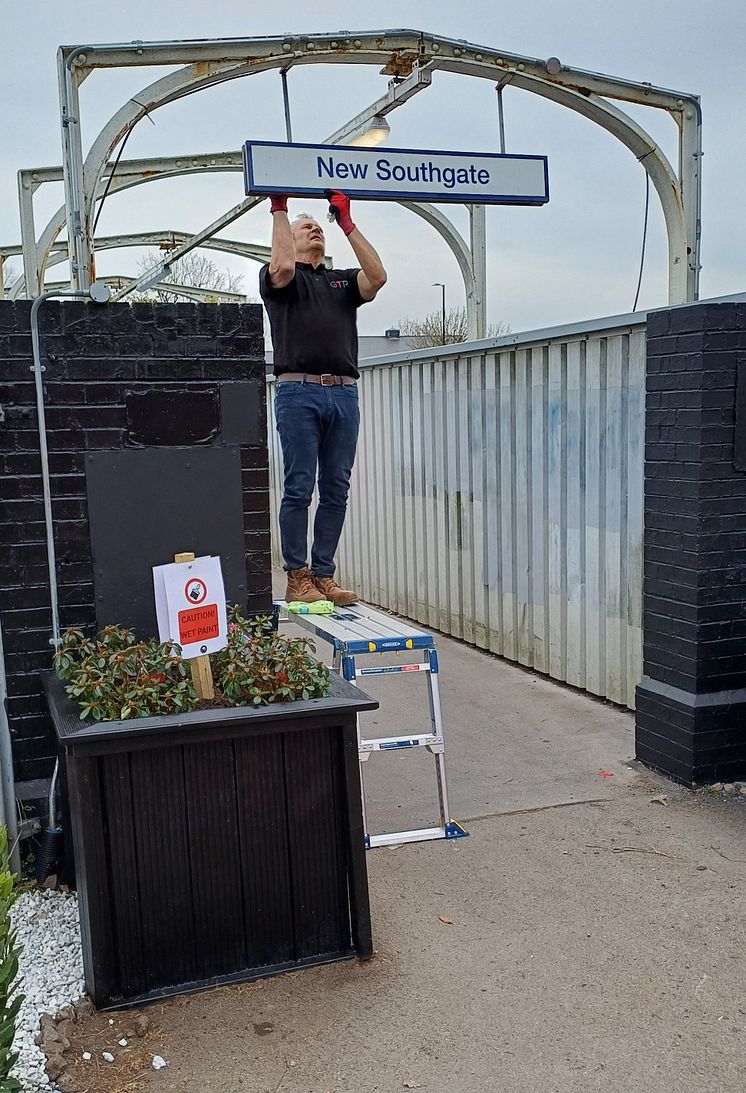 Infrastructure Director Keith Jipps works on New Southgate's station sign.jpg