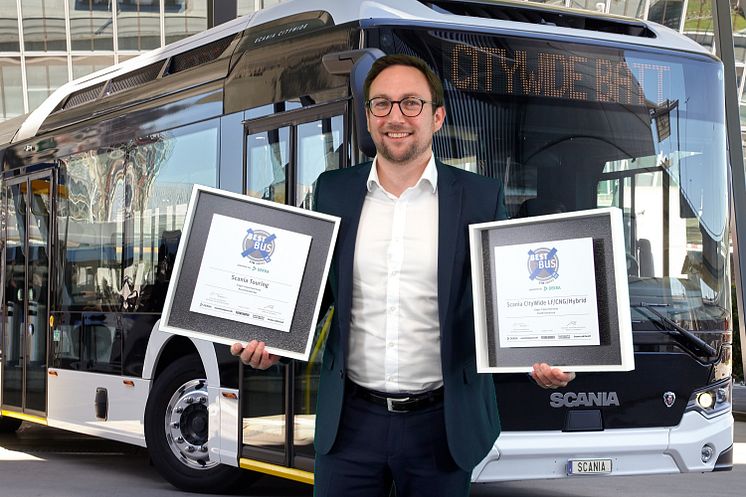 Luc Moulin, Direktor Verkauf Busse, Scania Deutschland Österreich präsentiert stolz die Awards der Scania Busse.
