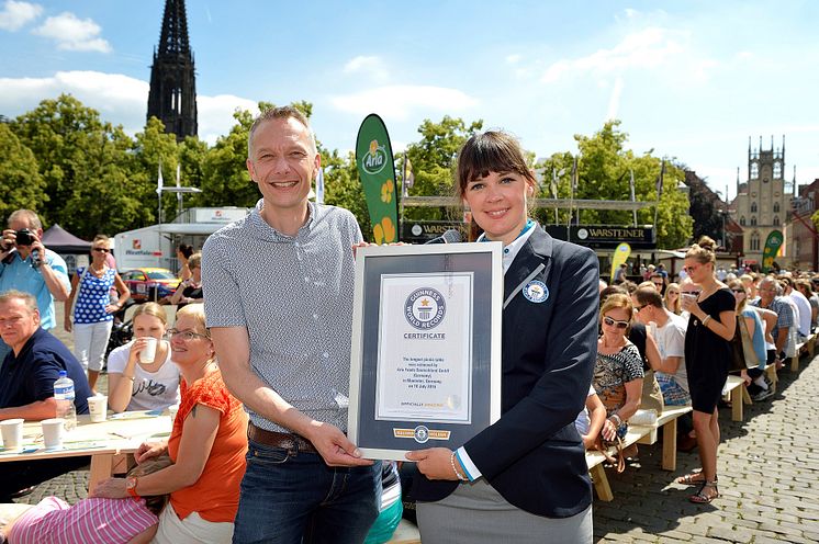 Lena Kuhlmann, Schiedsrichterin von GUINNESS WORLD RECORDS®  überreicht Tino Gottschalk, Geschäftsführer von Arla Foods Deutschland, die offizielle Urkunde. 