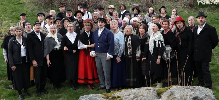 Et kor som synger, ikledd gammeldagse klær.