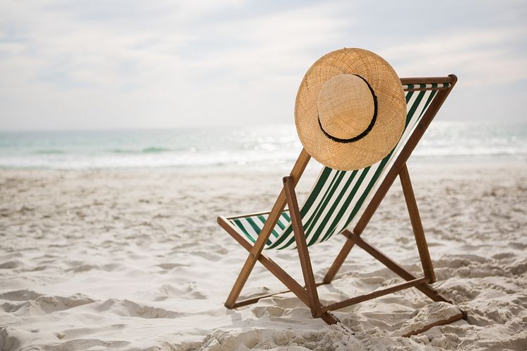 straw-hat-kept-empty-beach-chair