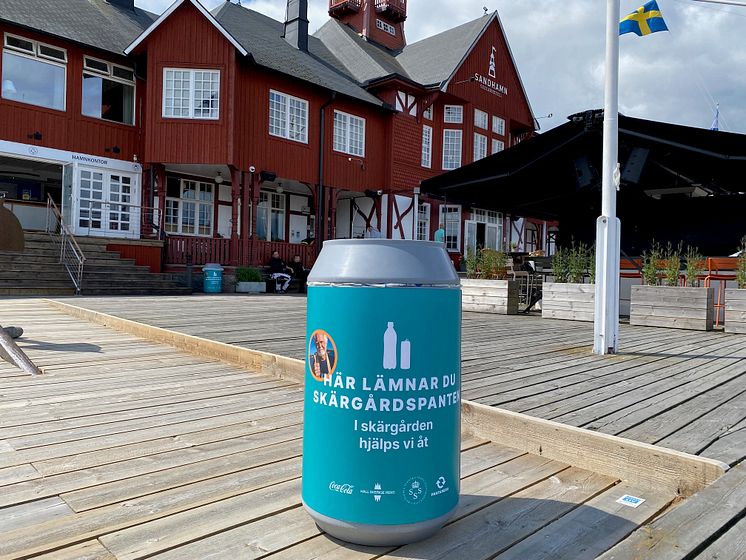 Bild på pantkärl framför ett rött hus