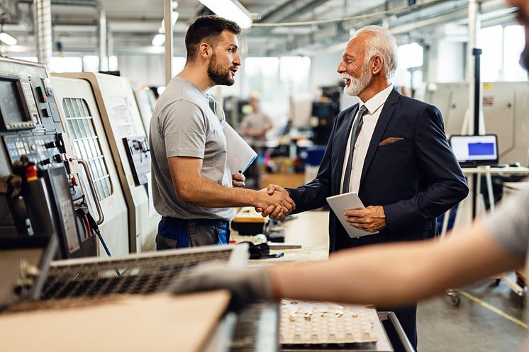 Worker and boss with CNC machine - Drazen Zigic_shutterstock_1435888007