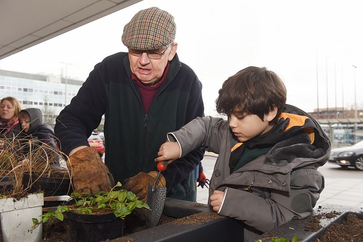 Milton Keynes Model Railway Society and local children fill planters at Milton Keynes station