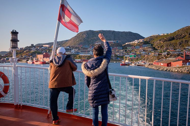 Passengers wave flag Sarfaq Ittuk. Photo - Lisa Germany Visit Greenland