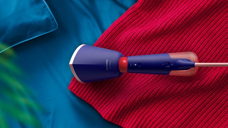 Philips håndholdt steamer på en rød strikkegenser