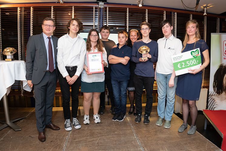 Hermann Aigner übergibt den goldenen Fressnapf an das Projektteam "Biene" der Clara Fey Schule