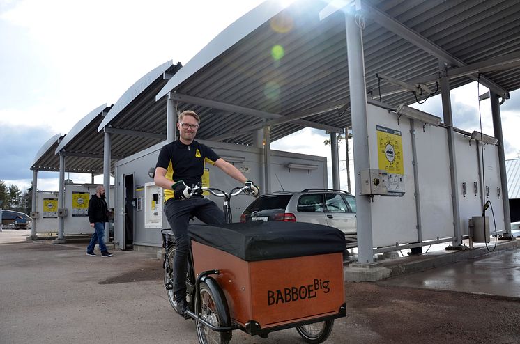 Anders Nygårds på elassisterad lådcykel framför tvättstationen i Falun