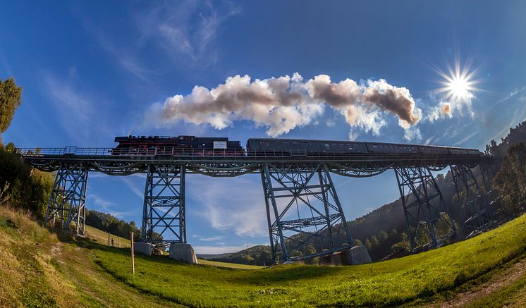 das Markersbacher Viadukt wird von einem historischen Zug der Erzgebirgischen Aussichtsbahn überquert