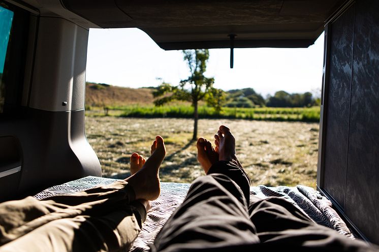 Eiderstedt_Camper_liegen_im_Van_und_blicken_in_die_Landschaft