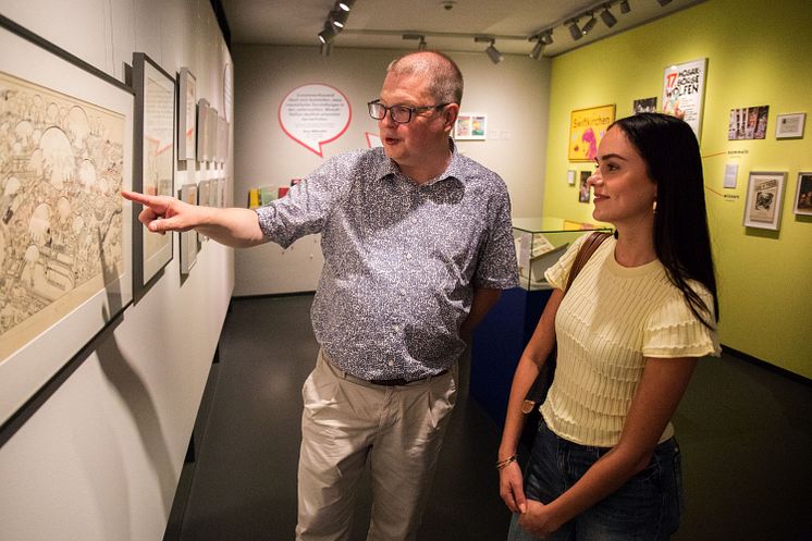 Michael Hebestreit erläutert einer Besucherin die Hintergründe der Ausstellung. 