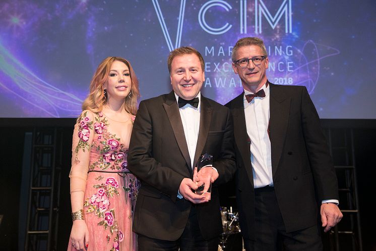 Stephen King (centre) collects his award from comedian and host Katherine Ryan and sponsor Paul Carr of Stopgap