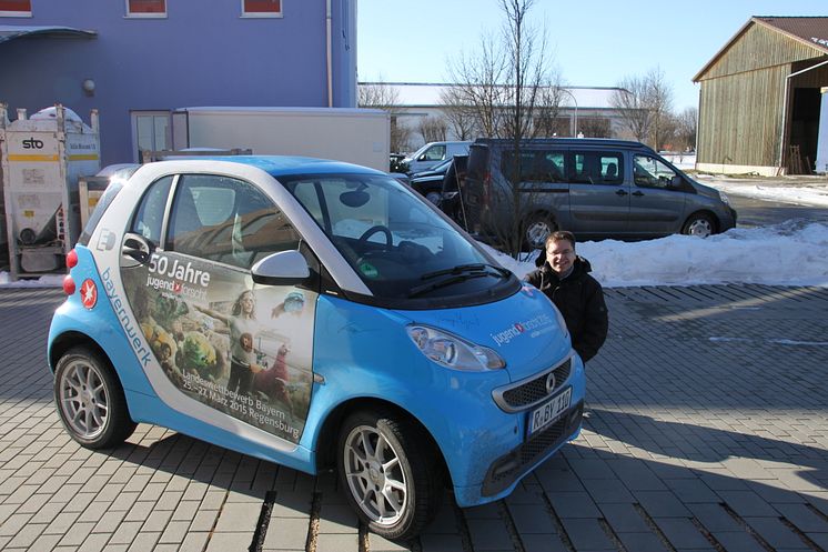 Mit dem „50 Jahre Jugend forscht E-Smart“ trifft das Patenunternehmen Bayernwerk ehemalige bayerische Preisträger und lässt diese das Elektroauto signieren.