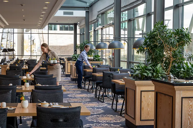 Tische im Restaurant werden von zwei Mitarbeiterinnen eingedeckt