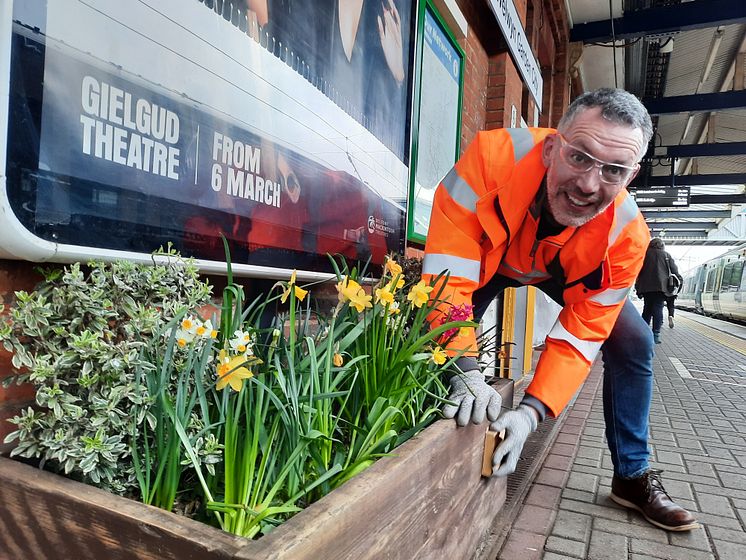 A volunteer tidies up one of the station's flower beds