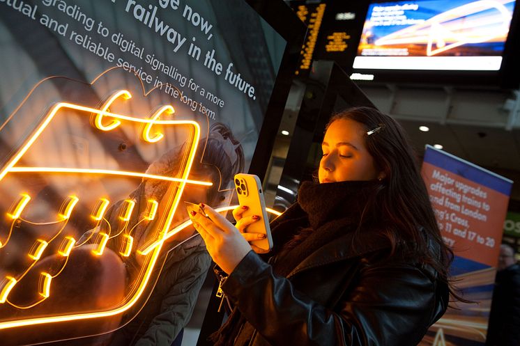 Passenger scanning ECDP card for service information at King's Cross, Network Rail