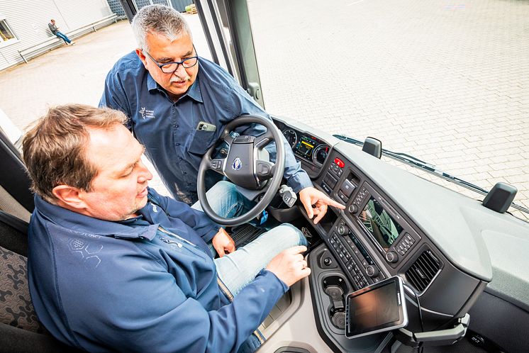 Fahrlehrer Frank Hartmann erklärt Lkw-Fahrer Enrico Wachsmann, welche Funktionen er im Cockpit des Scania 25 P vorfindet.