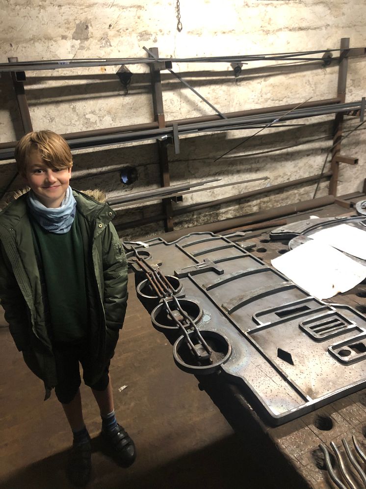 Monty, 9, with the train sculpture forged to his design 