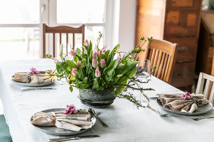 Tulpanarrangemang med kvistar på bord