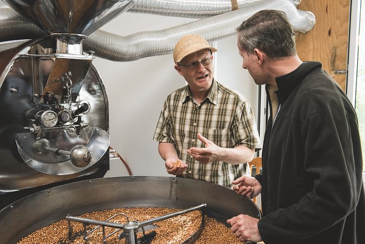 Ilario Garbani (li) und Besucher beim Mais-Mahlen, Tessin