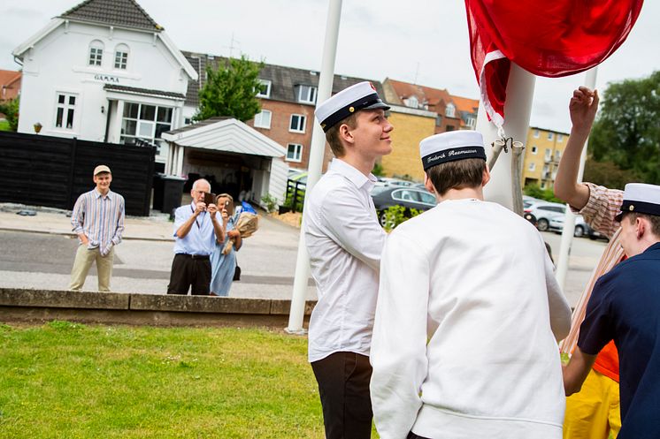 De første studenter på Tradium HTX hejser flaget foran skolen.